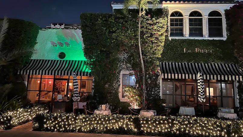 La Jolla on Alcazar Avenue at night, its hedges wrapped in warm string lights.