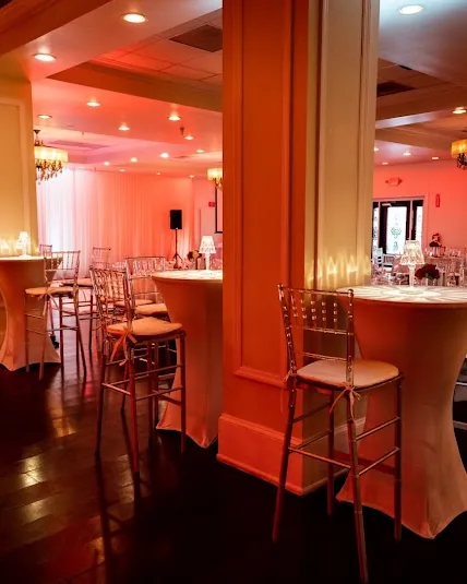 Cocktail tables and columns washed in warm amber light.