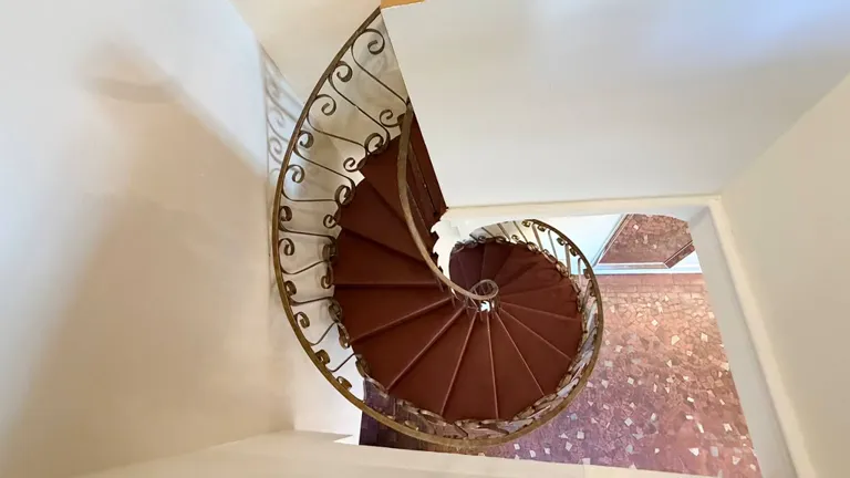 Curved staircase with a decorative iron railing inside La Jolla.